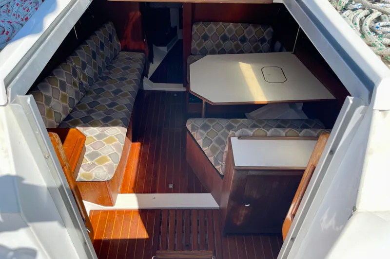 Slide: The Image of Interior of 1985 Hunter 31 sailboat with patterned seating and wooden flooring. - 11