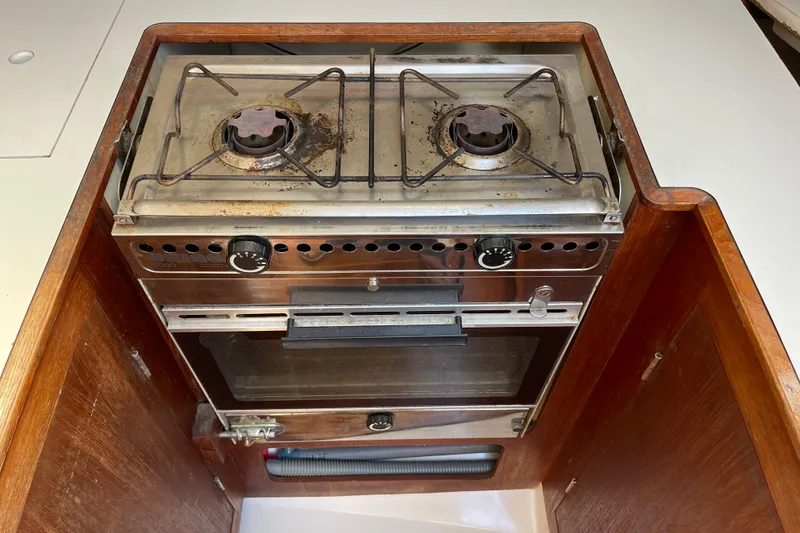 Slide: The Image of Vintage 1985 Hunter 31 boat stove with dual burners and oven in wooden enclosure. - 16