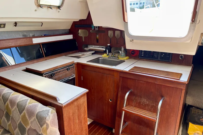 Slide: The Image of Interior of 1985 Hunter 31 sailboat galley with wood cabinetry and compact kitchen setup. - 18