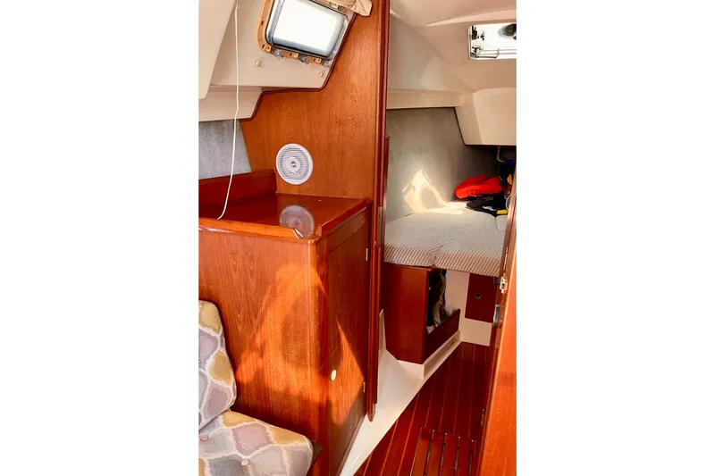 Slide: The Image of Interior of 1985 Hunter 31 sailboat with wooden cabinetry and cozy sleeping area. - 25