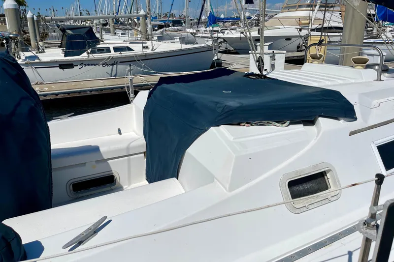 Slide: The Image of 1985 Hunter 31 sailboat docked at marina with blue covers. - 3
