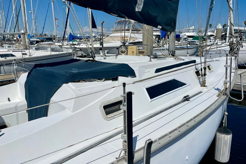 Slide: The Image of 1985 Hunter 31 sailboat docked in marina, featuring white hull and blue covers. - 4