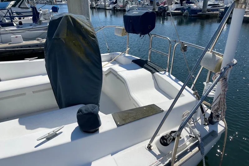 Slide: The Image of 1985 Hunter 31 sailboat cockpit with covered equipment, docked in a marina. - 7