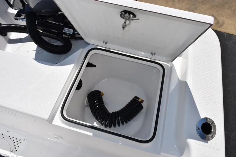 Slide: The Image of Open storage compartment on 2026 Frontier 180 boat with coiled hose inside. - 16