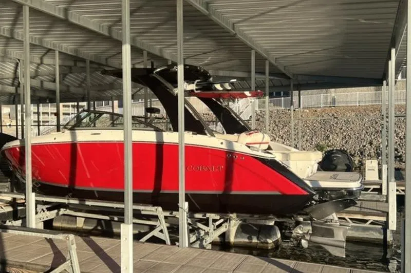 Slide: The Image of 2018 Cobalt R5 Surf boat in dock, vibrant red hull, under covered marina. - 14