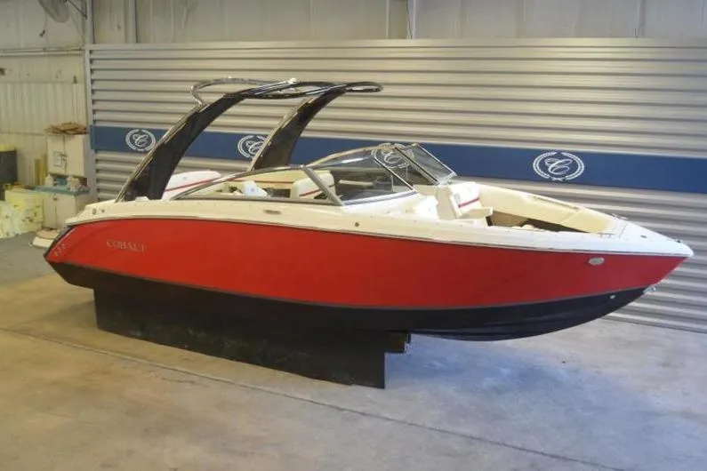 Slide: The Image of 2018 Cobalt R5 Surf boat in showroom, red and white exterior, sleek design. - 16