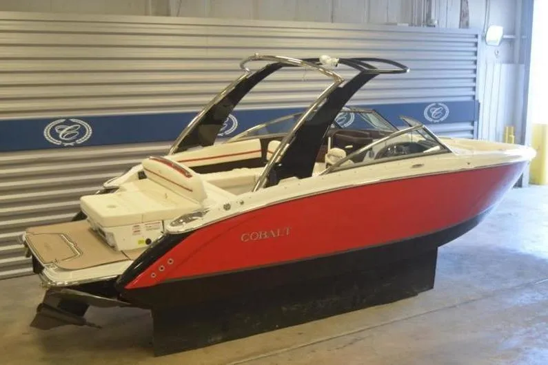 Slide: The Image of 2018 Cobalt R5 Surf boat in a showroom, featuring a sleek red and white design. - 17