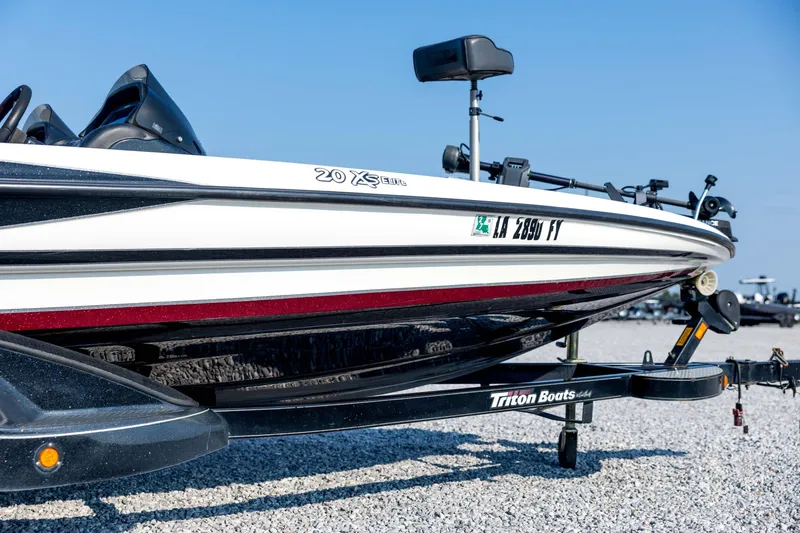 Slide: The Image of 2011 Triton 20XS DC boat on trailer, parked on gravel under clear blue sky. - 14