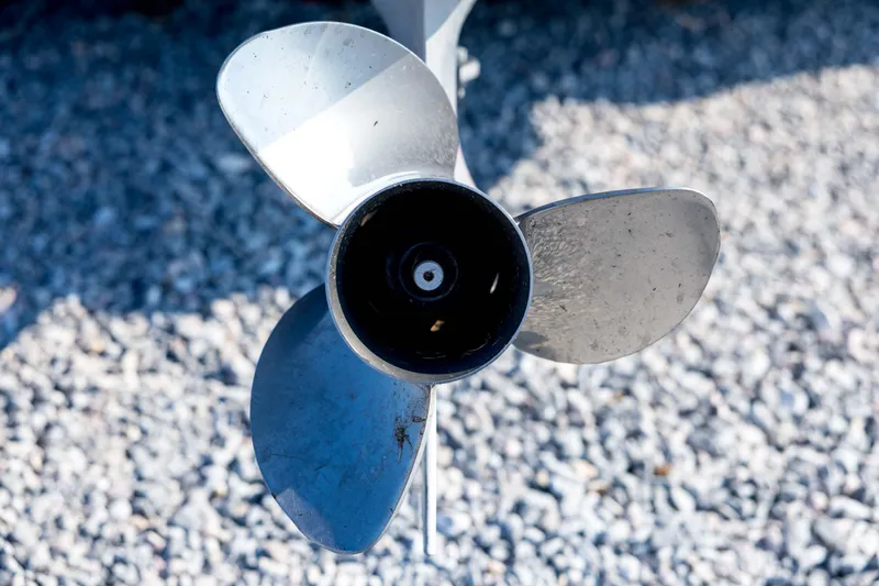 Slide: The Image of Close-up of a Triton 20XS DC 2011 boat propeller on gravel surface. - 18