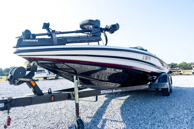 Slide: The Image of 2011 Triton 20XS DC boat on trailer with Lowrance equipment, parked on gravel. - 28