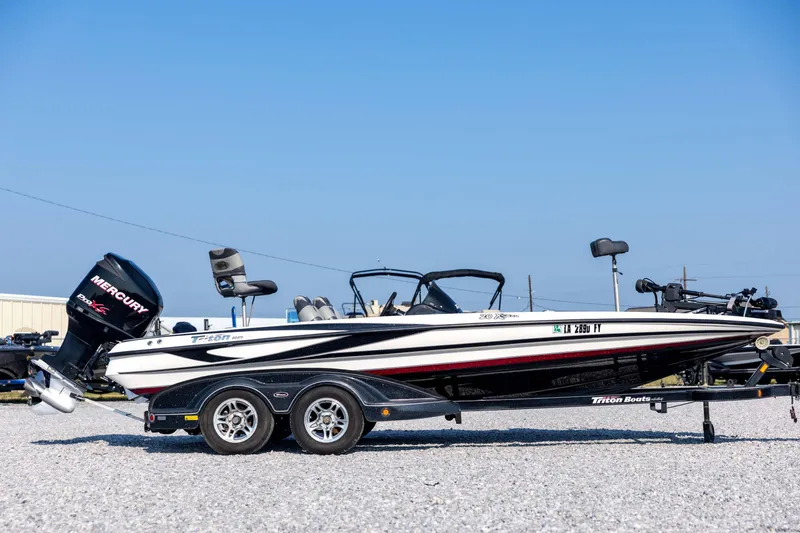 Slide: The Image of 2011 Triton 20XS DC boat with Mercury engine on trailer, parked outdoors. - 4