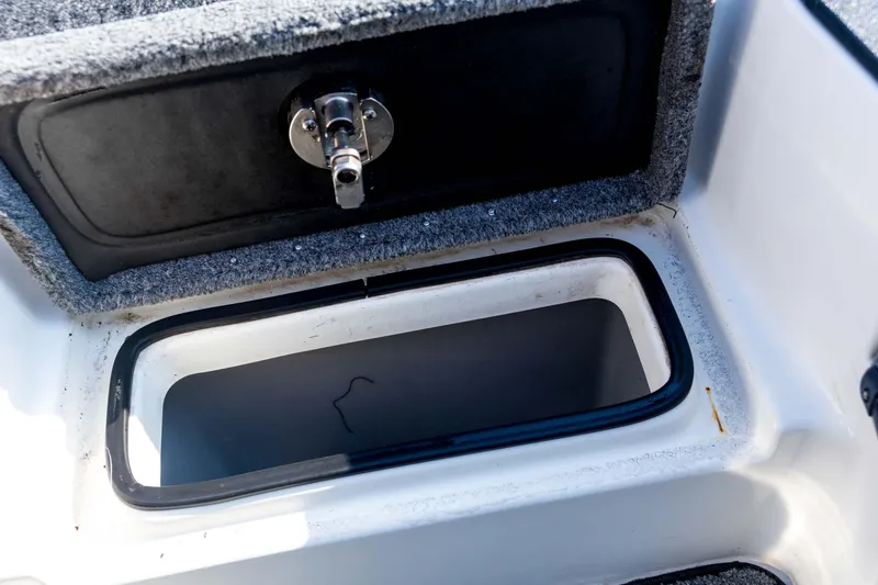 Slide: The Image of Open storage compartment in 2011 Triton 20XS DC boat, featuring a secure latch. - 47