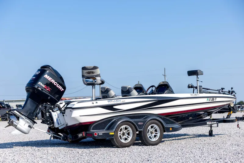 Slide: The Image of 2011 Triton 20XS DC boat with Mercury engine on a trailer, parked on gravel. - 5