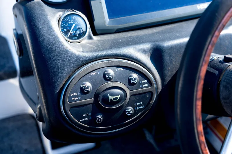 Slide: The Image of Control panel of a 2011 Triton 20XS DC boat with various buttons and gauges. - 52