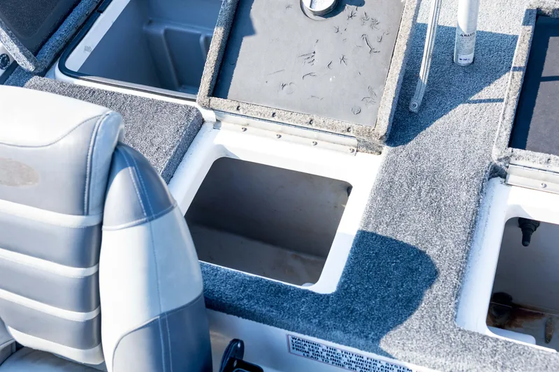 Slide: The Image of 2011 Triton 20XS DC boat interior with open storage compartments and cushioned seat. - 66