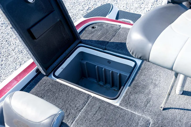 Slide: The Image of 2011 Triton 20XS DC boat storage compartment with open lid and seating area. - 69