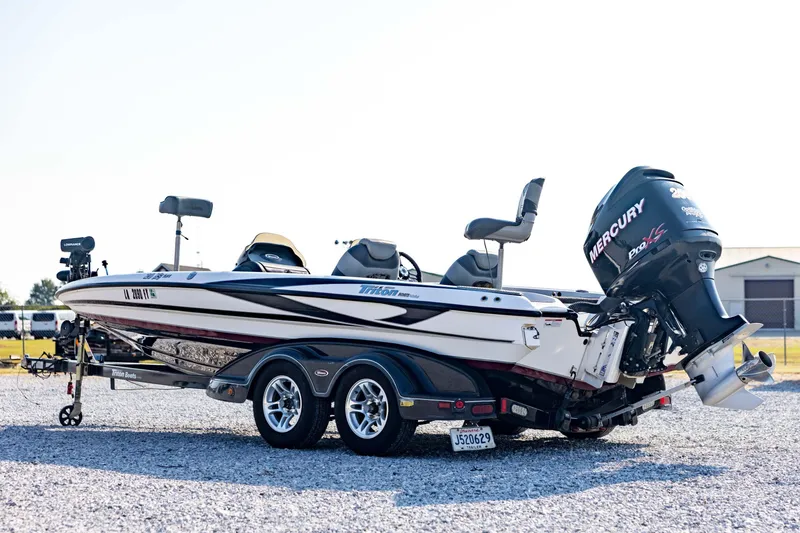 Slide: The Image of 2011 Triton 20XS DC boat with Mercury engine on a trailer, parked on gravel. - 7