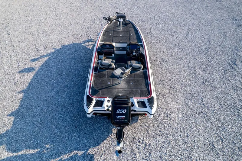 Slide: The Image of 2011 Triton 20XS DC boat on gravel, aerial view, showcasing seating and motor. - 75
