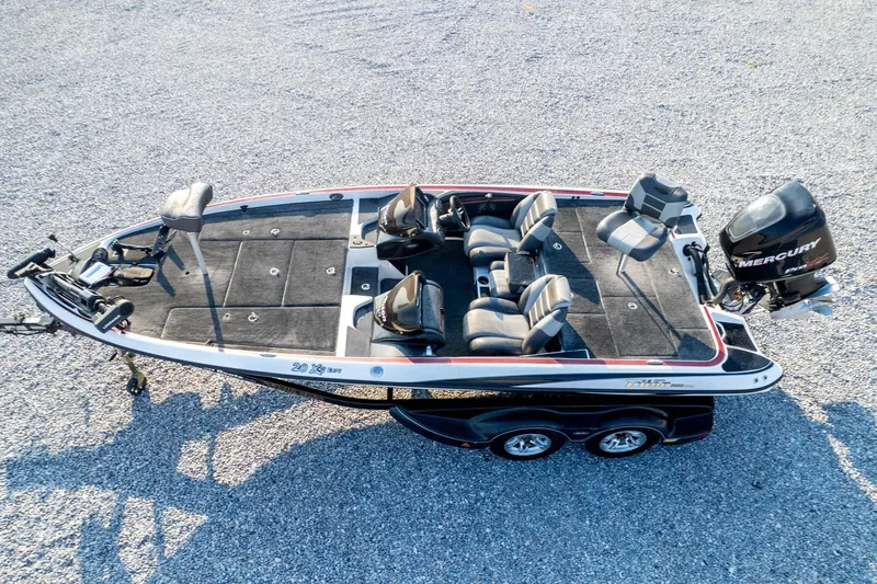 Slide: The Image of 2011 Triton 20XS DC boat with Mercury engine on gravel surface. - 77