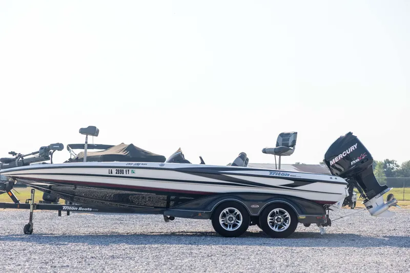 Slide: The Image of 2011 Triton 20XS DC boat with Mercury engine on a trailer, parked on gravel. - 8