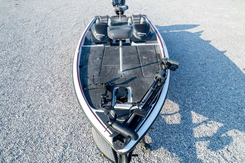 Slide: The Image of 2011 Triton 20XS DC boat on gravel, featuring dual seats and fishing equipment. - 83