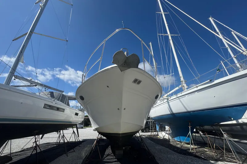 Slide: The Image of 1999 Sea Ray Sundancer 400 yacht in dry dock, surrounded by sailboats under a clear blue sky. - 12