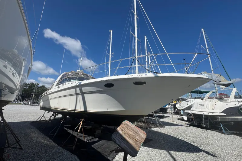 Slide: The Image of 1999 Sea Ray Sundancer 400 yacht on dry dock under clear blue sky. - 13