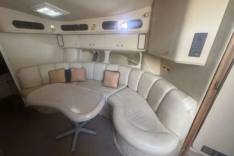 Slide: The Image of 1999 Sea Ray Sundancer 400 interior with curved leather seating and modern table. - 25