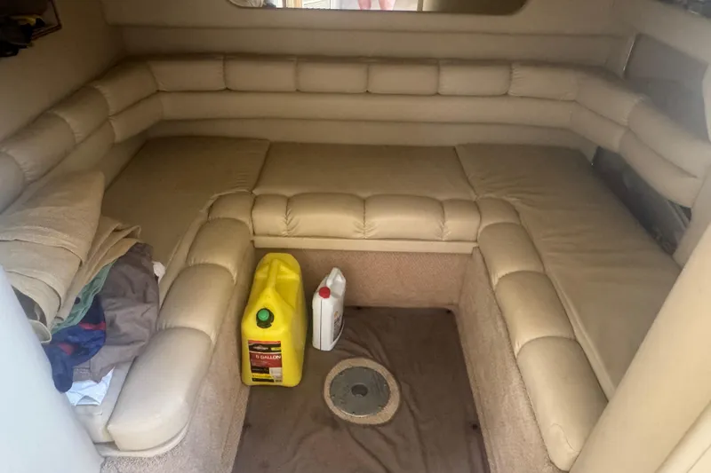 Slide: The Image of Interior of 1999 Sea Ray Sundancer 400 with beige seating and cleaning supplies. - 27