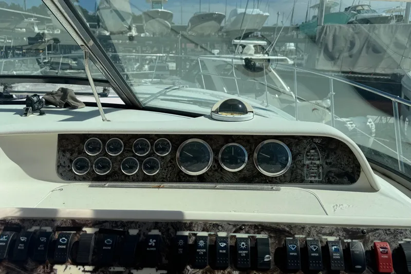 Slide: The Image of 1999 Sea Ray Sundancer 400 dashboard with gauges and controls, docked at a marina. - 29