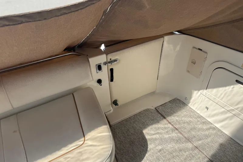 Slide: The Image of 1999 Sea Ray Sundancer 400 interior with beige seating and carpeted flooring. - 34