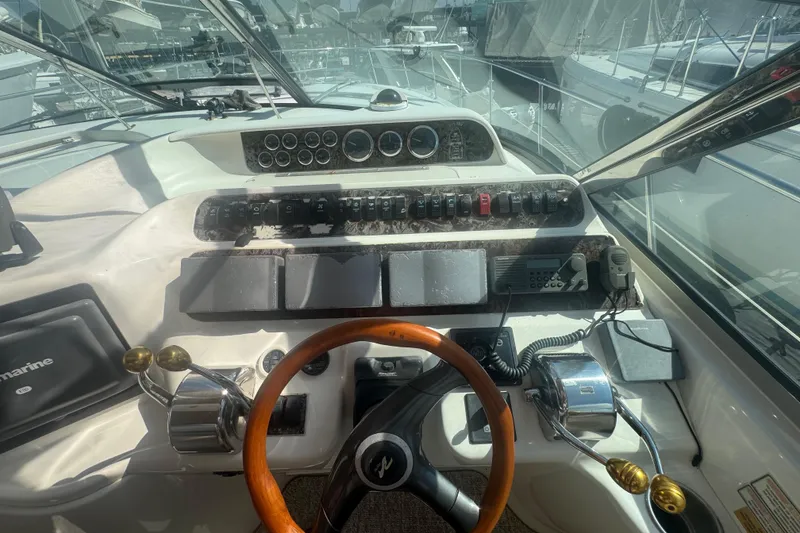 Slide: The Image of 1999 Sea Ray Sundancer 400 helm with wooden steering wheel and control panel. - 36