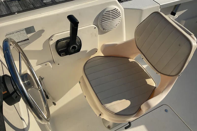 Slide: The Image of 2002 Trophy 1802 Walkaround boat helm with steering wheel and cushioned seat. - 11