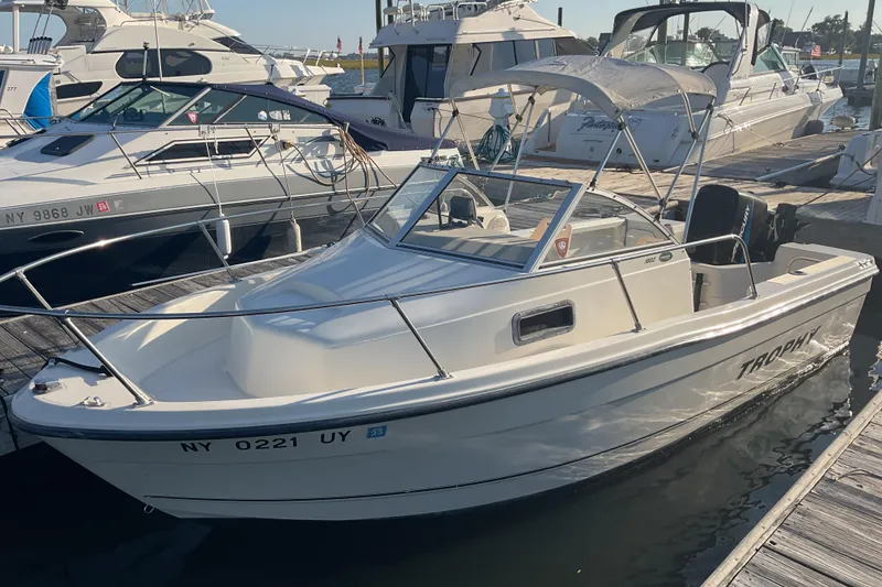 Slide: The Image of 2002 Trophy 1802 Walkaround boat docked at marina, surrounded by other vessels. - 2