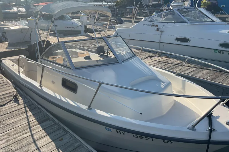 Slide: The Image of 2002 Trophy 1802 Walkaround boat docked at marina under sunny skies. - 4
