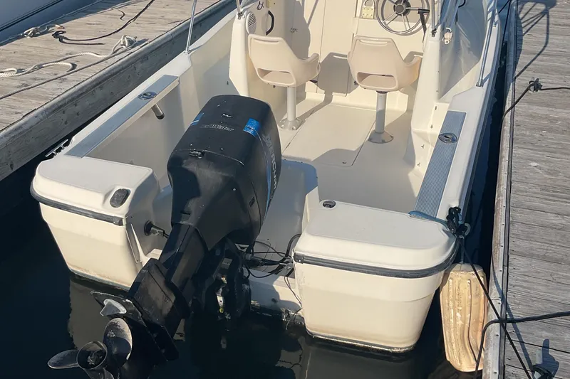 Slide: The Image of 2002 Trophy 1802 Walkaround boat docked, featuring outboard motor and dual seating. - 7