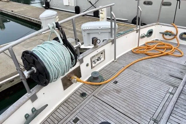 Slide: The Image of 1984 Grand Banks Classic yacht deck with coiled rope and dockside view. - 12