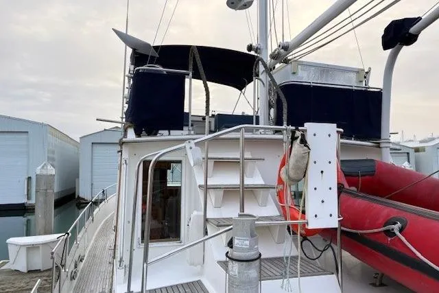 Slide: The Image of 1984 Grand Banks Classic yacht with upper deck, docked near storage units. - 17