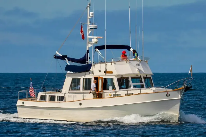 Slide: The Image of 1984 Grand Banks 49 Classic yacht cruising on open sea with passengers onboard. - 2