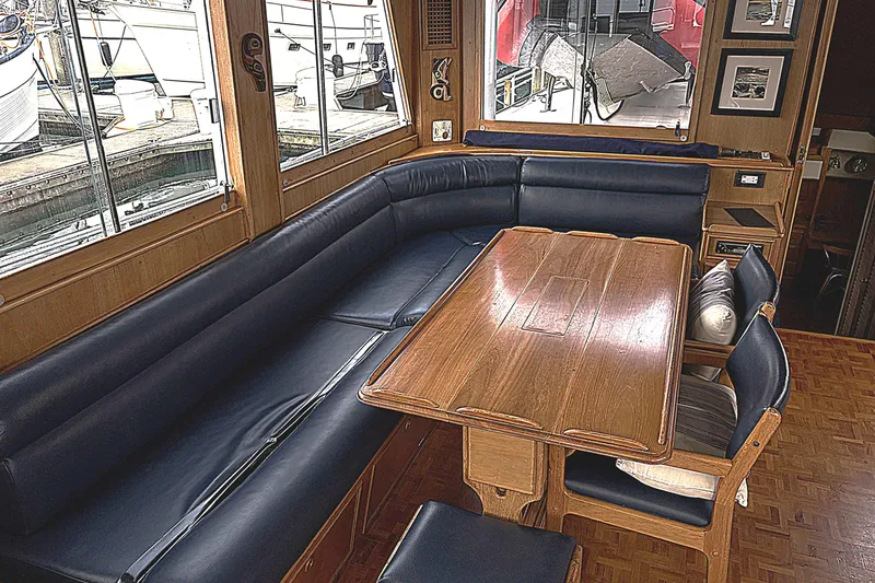 Slide: The Image of 1984 Grand Banks Classic yacht interior with wooden table and blue seating. - 23