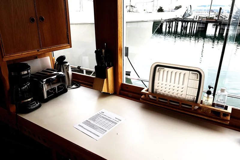 Slide: The Image of 1984 Grand Banks Classic kitchen with appliances, dockside view through window. - 27