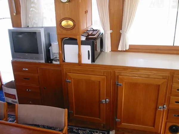 Slide: The Image of 1984 Grand Banks Classic interior with wooden cabinetry, TV, and appliances. - 28