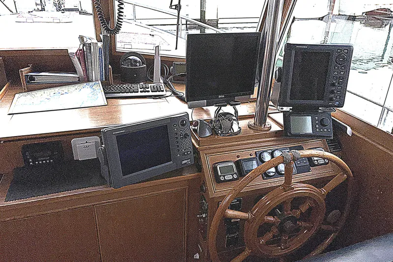 Slide: The Image of 1984 Grand Banks Classic helm with navigation equipment and wooden steering wheel. - 32
