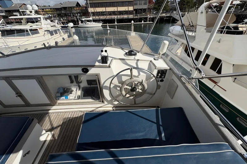 Slide: The Image of 1984 Grand Banks Classic yacht helm with blue seating, docked in a marina. - 5
