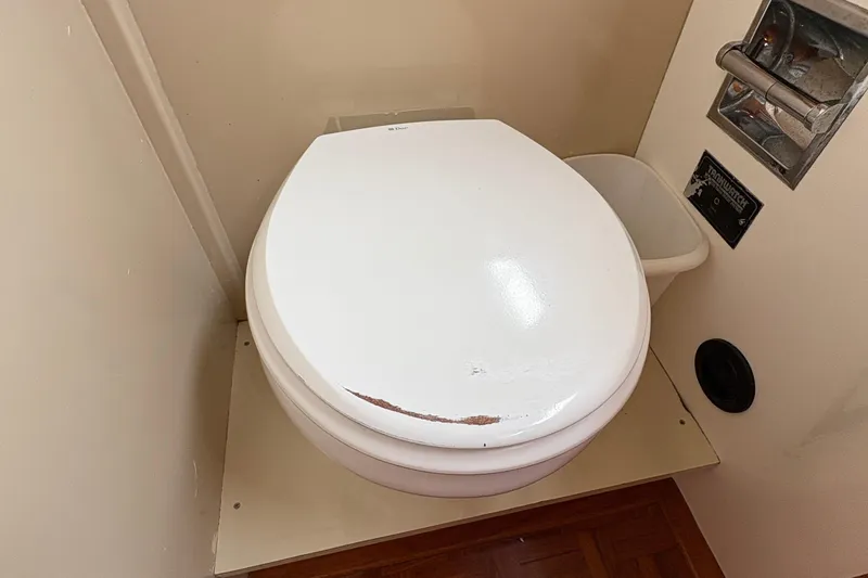 Slide: The Image of Toilet in 1984 Grand Banks Classic boat bathroom, featuring a white seat and compact design. - 50
