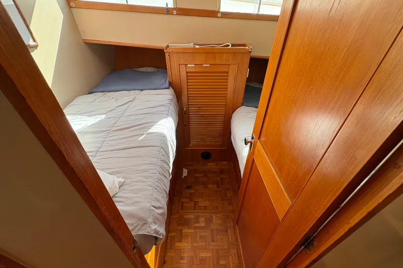 Slide: The Image of 1984 Grand Banks Classic cabin interior with twin beds and wooden paneling. - 53