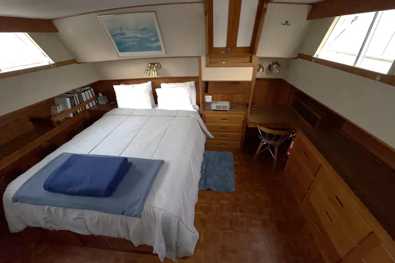 Slide: The Image of Cozy bedroom in 1984 Grand Banks Classic yacht with wood furnishings and nautical decor. - 55
