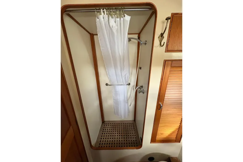 Slide: The Image of 1984 Grand Banks Classic shower with wooden accents and white curtain. - 61