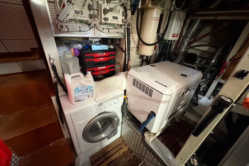 Slide: The Image of Laundry area in 1984 Grand Banks Classic boat engine room with washer and dryer. - 63