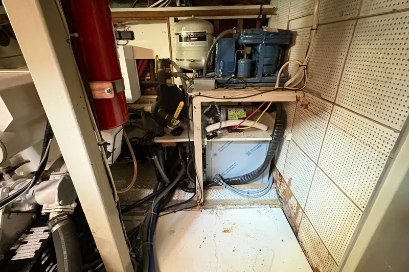 Slide: The Image of Engine room of 1984 Grand Banks 49 Classic yacht with equipment and fire extinguisher. - 65